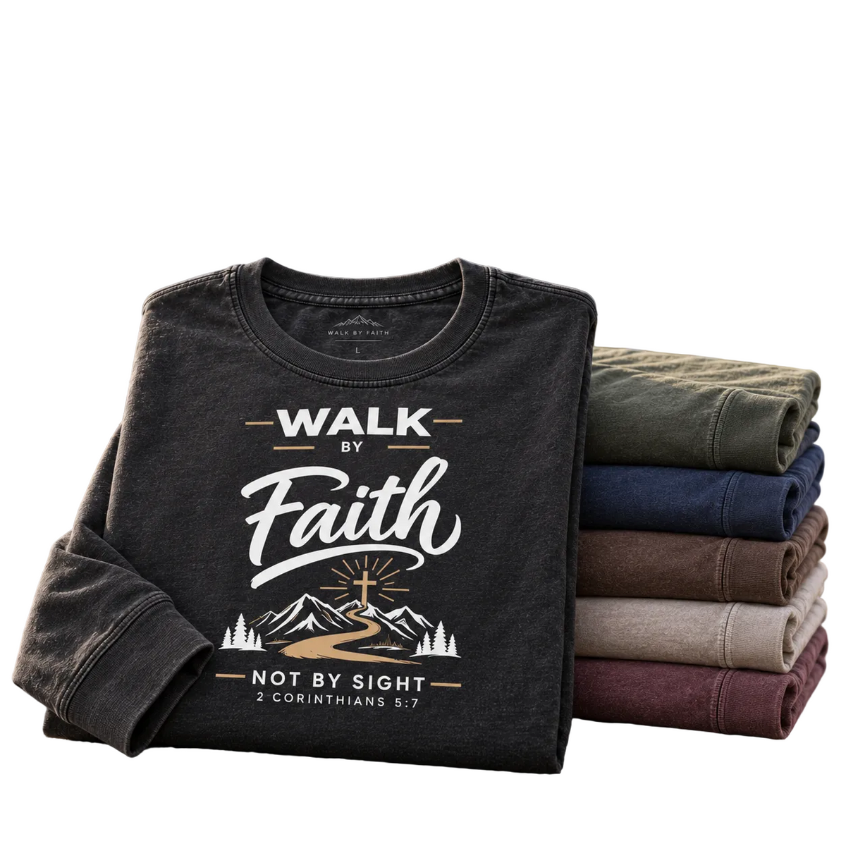 A dark charcoal long-sleeve graphic T-shirt is displayed on a rock with a stack of folded shirts in other colors behind it, and mountain scenery in the background. Large text at the top reads 'Christian Long Sleeve Tees' with supporting copy.